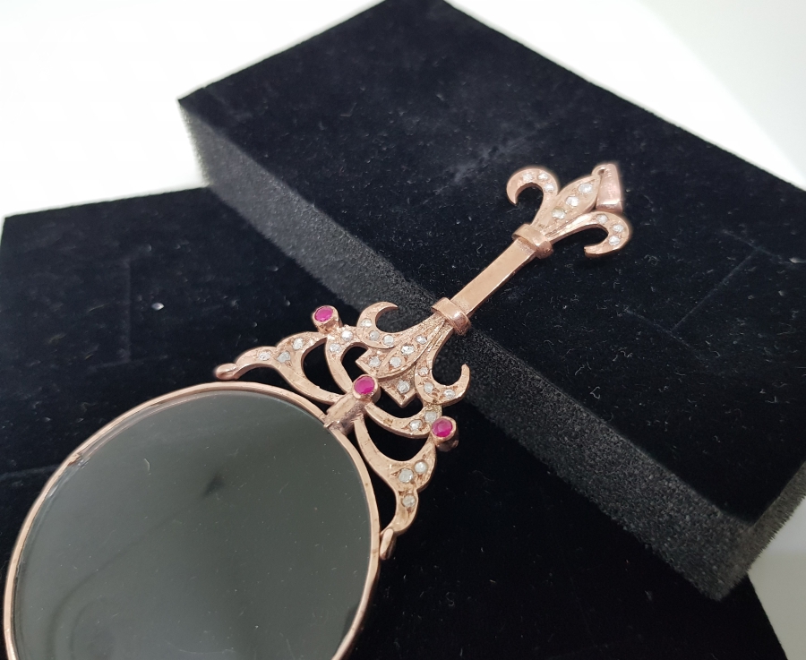 KARNİK ÇİÇEĞİ FORMUNDA YAPILMIŞ ELMAS VE YAKUT TAŞLI KOLYE BÜYÜTEÇ