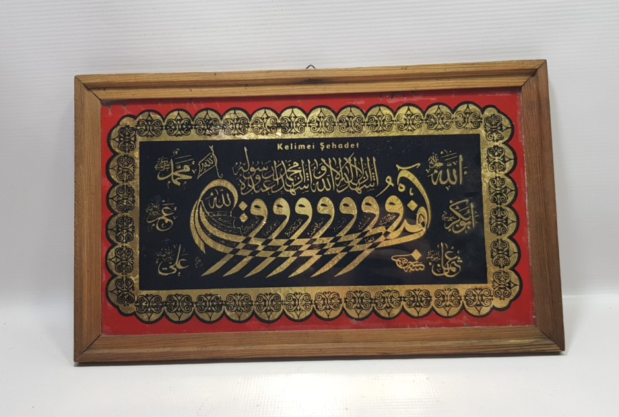 HÜSEYİN KETEBELİ VAV KAYIĞI FORMUNDA KELİME-İ ŞEHADET YAZILI CAM ALTI HAT LEVHA