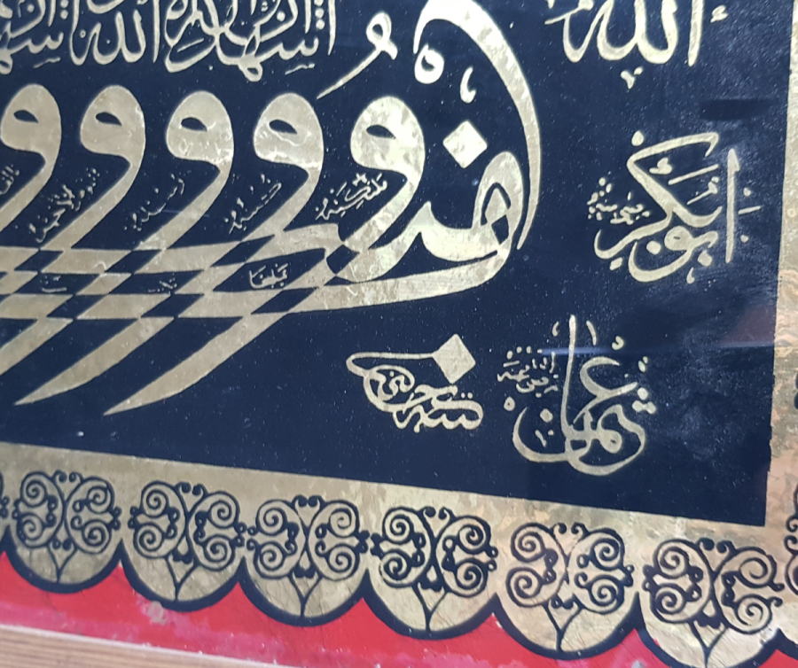 HÜSEYİN KETEBELİ VAV KAYIĞI FORMUNDA KELİME-İ ŞEHADET YAZILI CAM ALTI HAT LEVHA